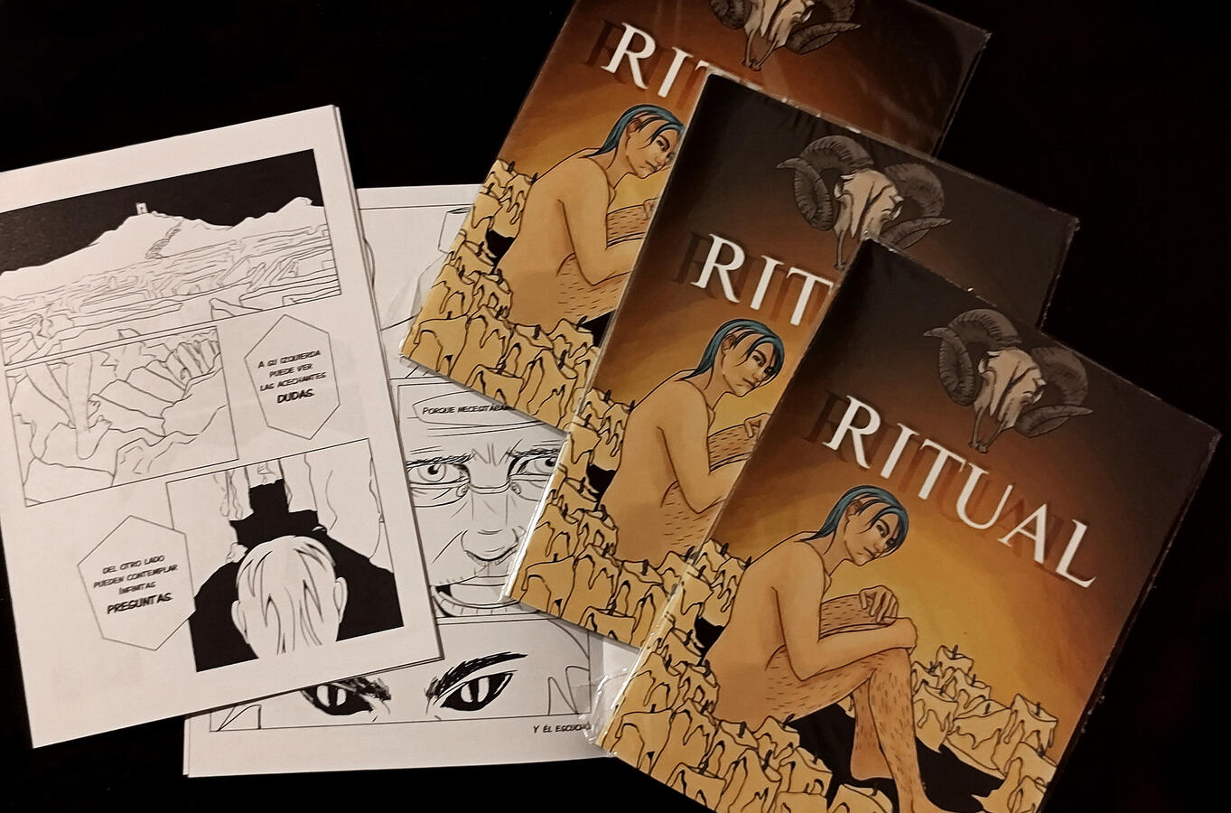 Several copies of a zine piled on a dark background. The cover has an illustration of a person sitting inside a circle of candles